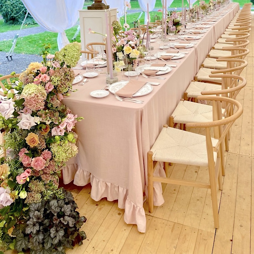Leinentischdecke Champagner mit Rüsche in elegantem Zeltaufbau, festlich gedeckter Tisch mit Blumenarrangement und Fine Art Dekoration
