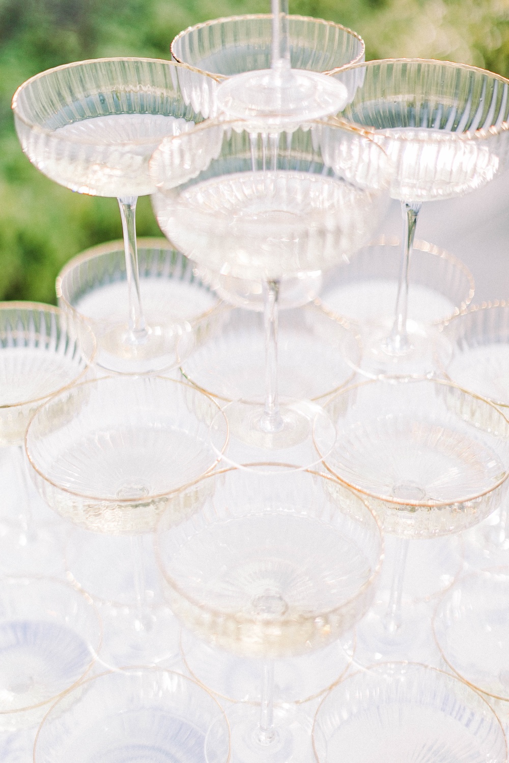 Detailaufnahme einer Champagnerpyramide mit gerippten, goldgeränderten Sektschalen. Die perfekte Wahl für stilvolle Events – jetzt mieten!